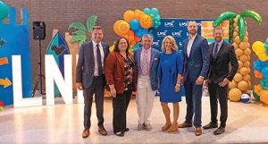 A group of people standing in front of LNK letters