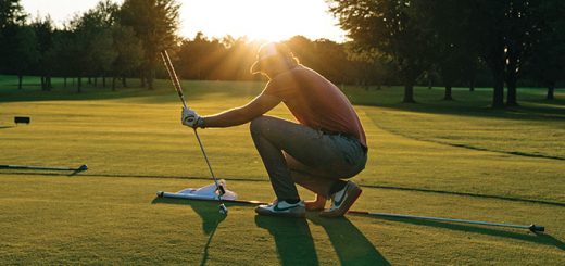 a man crouches on the golf green