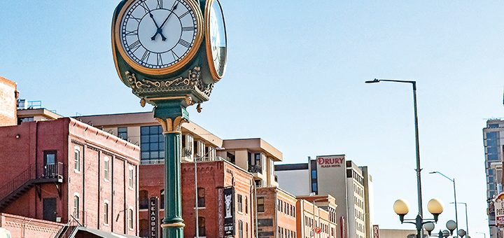 an ornate clock in a busy downtown area