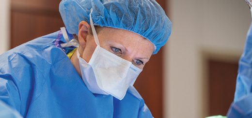 a surgeon operating in blue scrubs