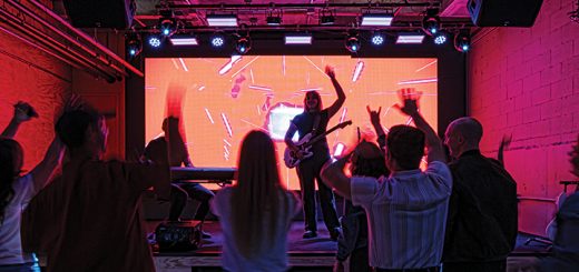 an audience in a dark room as an artist performs
