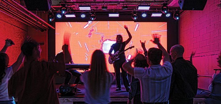 an audience in a dark room as an artist performs