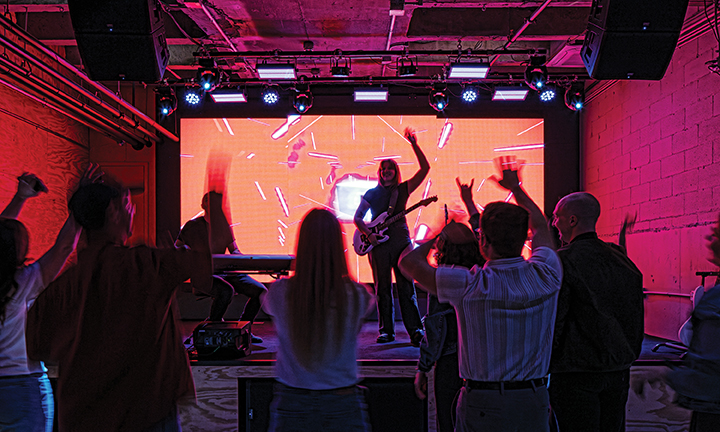 an audience in a dark room as an artist performs